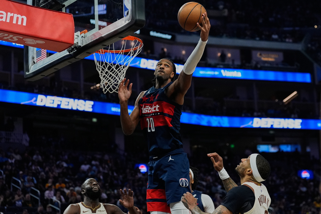 Washington Wizards center Alex Sarr (20) rebounds the ball next to Golden State Warriors guard Gary Payton II, right, during the first half of an NBA basketball game, Friday, March 27, 2026, in San Francisco. (AP Photo/Godofredo A. Vásquez)