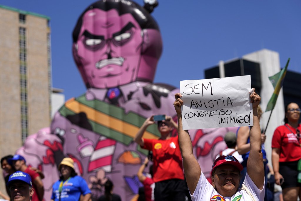 A demonstrator holds up a sign that reads in Portuguese, "No amnesty, enemy Congress," in front of a doll of former president Jair Bolsonaro as a prisoner, during a protest against an amnesty bill that could absolve Bolsonaro and his allies convicted for a 2023 coup attempt, in Brasilia, Brazil, Sunday, Sept. 21, 2025. (AP Photo/Eraldo Peres)