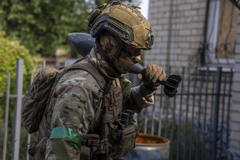 A Ukrainian serviceman known by the call sign "Akim" carries a mine close to the front line near Kostiantynivka, Ukraine, on Wednesday, Sept. 10, 2025. (AP Photo/Alex Babenko)