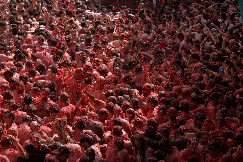 Revelers throw tomatoes at each other during the annual "Tomatina" tomato fight fiesta, in the village of Bunol near Valencia, Spain, Wednesday, Aug. 26, 2026. (AP Photo/Alberto Saiz)
