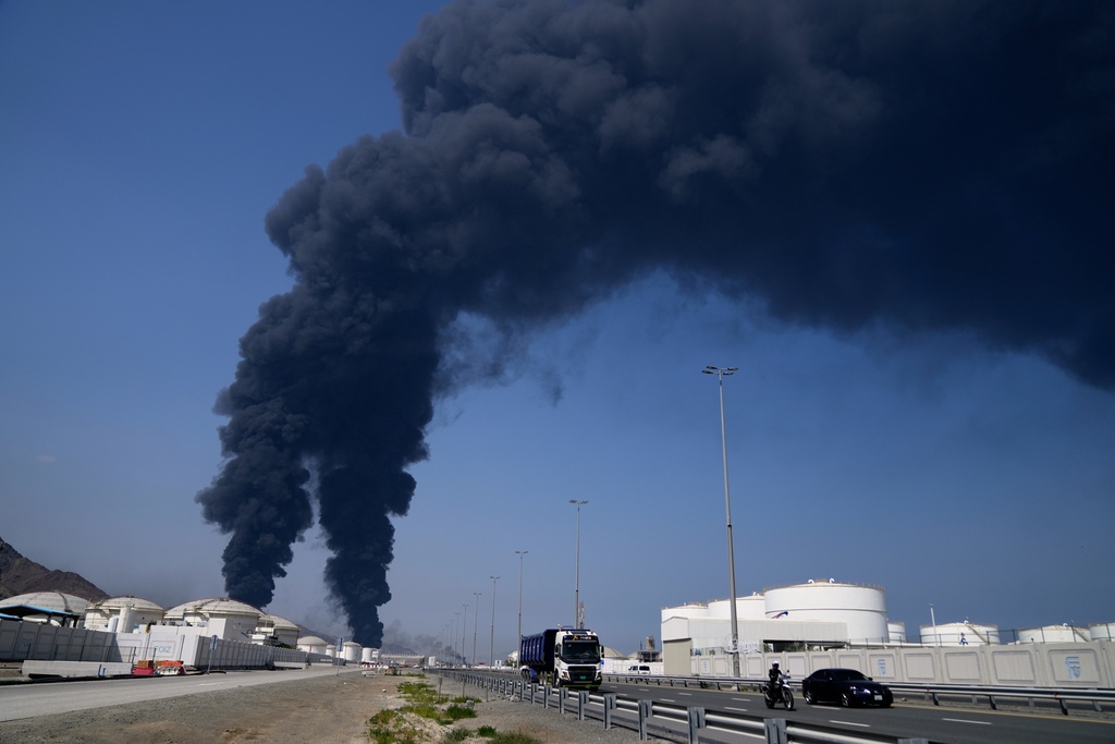 Plumes of smoke rise after debris from an intercepted Iranian drone struck an oil facility, according to authorities, in Fujairah, United Arab Emirates, Saturday, March 14, 2026. (AP Photo/Altaf Qadri)