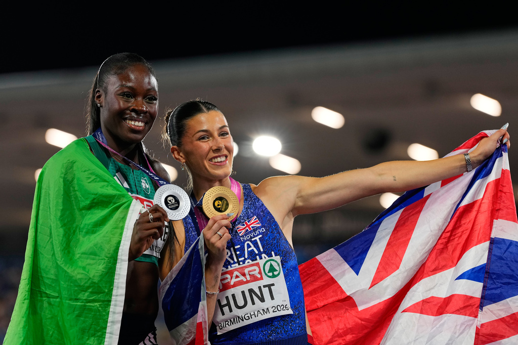 Amy Hunt of Britain celebrates winning the gold medal with Rhasidat Adeleke of Ireland, who took the silver, in the women's 200 meters final at the European Athletics Championships in Birmingham, England, Thursday, Aug. 13, 2026. (AP Photo/Petr David Josek)