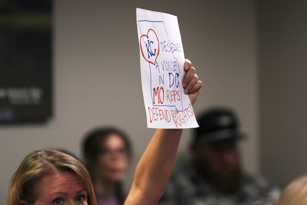 A person lifts a sign as Missouri lawmakers hold a committee hearing to consider redrawing the state's U.S. House districts Thursday, Sept. 4, 2025, in Jefferson City, Mo. (AP Photo/Jeff Roberson)