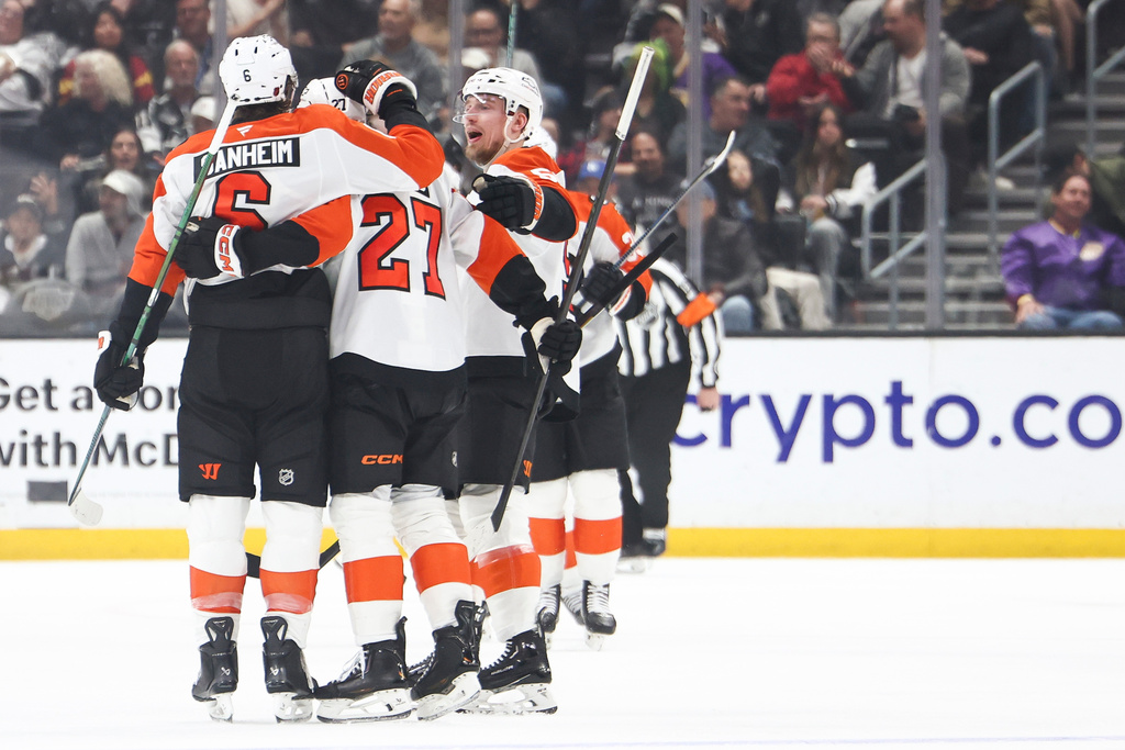 Philadelphia Flyers defenseman Travis Sanheim, left, celebrates with left wing Noah Cates (27) and defenseman Rasmus Ristolainen, right, after scoring a goal during the second period of an NHL hockey game against the Los Angeles Kings, Thursday, March 19, 2026, in Los Angeles. (AP Photo/Jessie Alcheh)