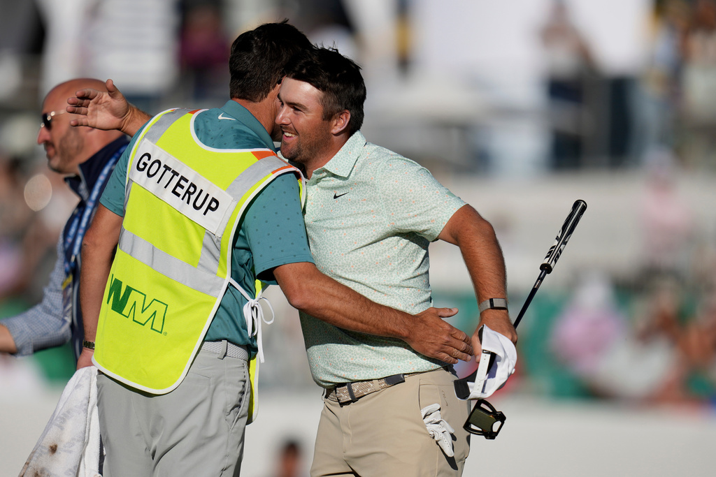 Chris Gotterup, right, smiles as he gets a hug from his caddie Brady Stockton after Gotterup's playoff win at the 18th hole during the final round of the Phoenix Open golf tournament Sunday, Feb. 8, 2026, in Scottsdale, Ariz. (AP Photo/Ross D. Franklin)