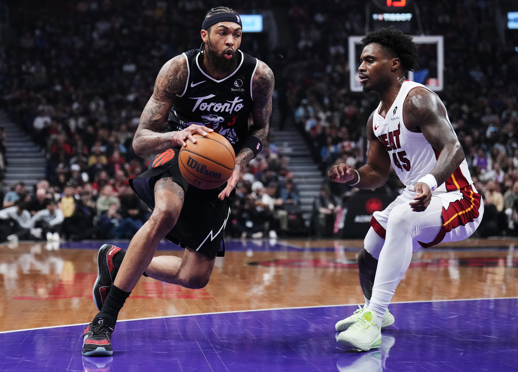 Toronto Raptors' Brandon Ingram (3) drives around Miami Heat's Davion Mitchell (45) during the first half of an NBA basketball game in Toronto, Thursday, April 9, 2026. (Nathan Denette/The Canadian Press via AP)
