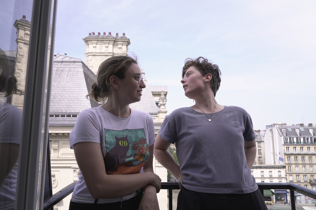 Amelie Kenney, right, and her partner Francesca Pilia stand on the balcony of the attic apartment they shares in Paris, Tuesday, June 23, 2026. (AP Photo/John Leicester)