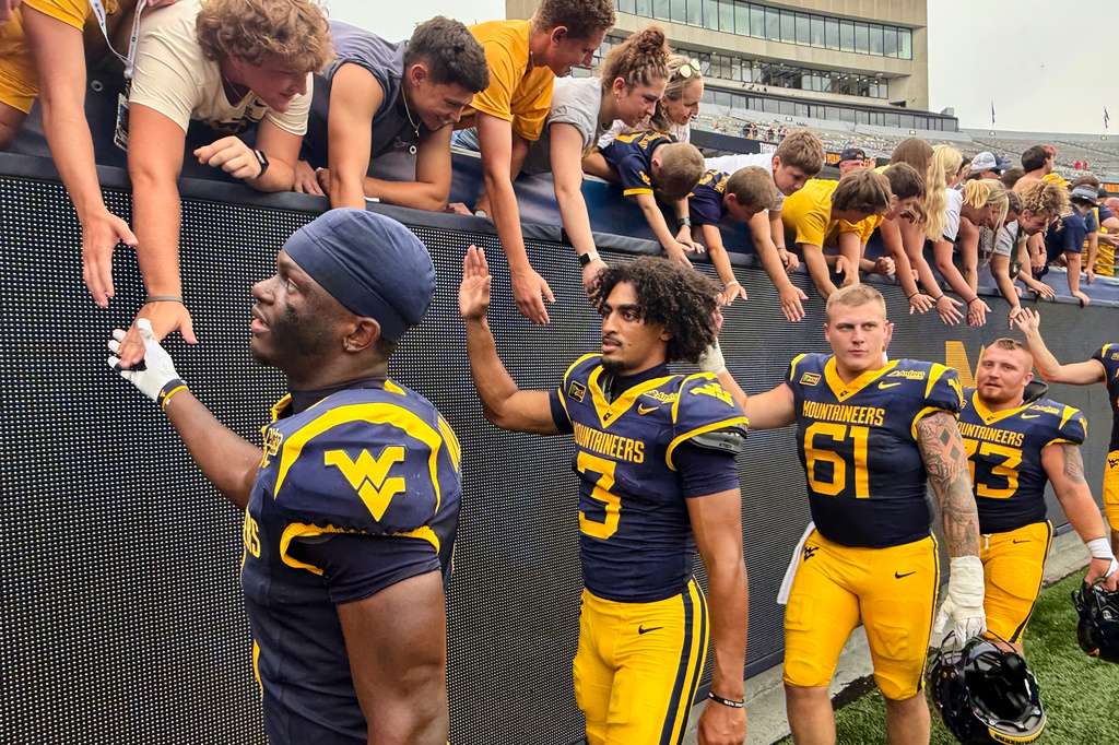 West Virginia quarterback Mike Hawkins Jr. (3) celebrates with fans and teammates after winning an NCAA college football game against UT Martin, Saturday, Sept. 12, 2026, in Morgantown, W.Va. (AP Photo/John Raby)