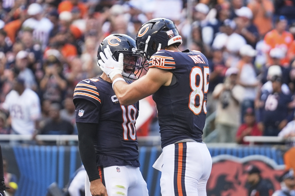 Chicago Bears' Caleb Williams (18) and Cole Kmet (85) celebrate after Kmet caught a touchdown pass in the first half of an NFL football game against the Dallas Cowboys Sunday, Sept. 21, 2025, in Chicago. (AP Photo/Erin Hooley)