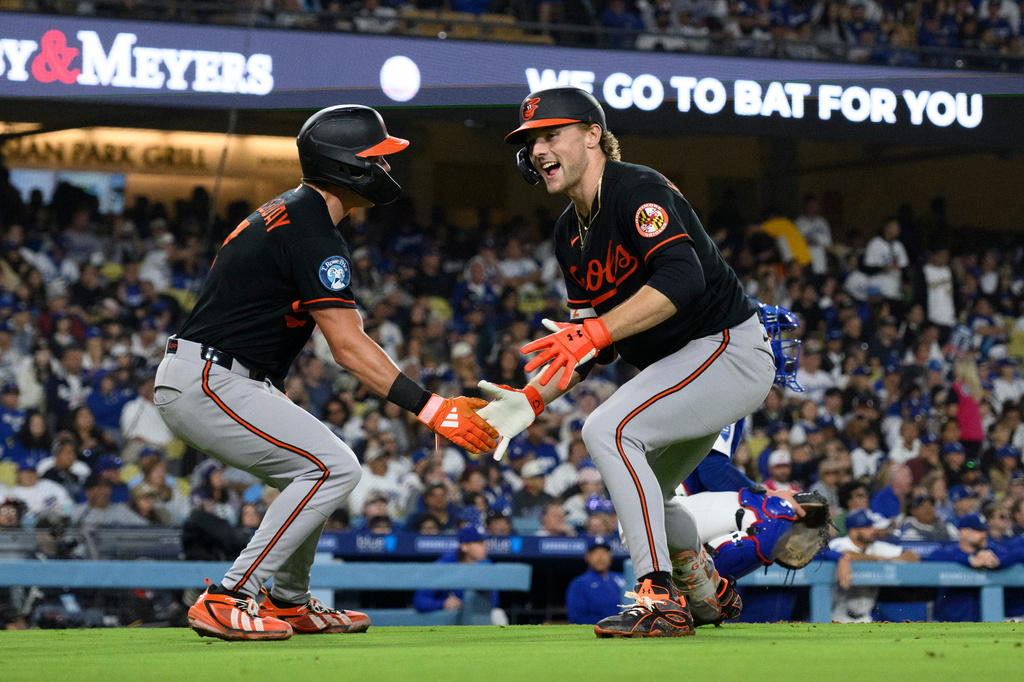 Baltimore Orioles' Gunnar Henderson, right, celebrates his two-run home run with Jackson Holliday during the sixth inning of a baseball game against the Los Angeles Dodgers in Los Angeles, Friday, June 19, 2026. (AP Photo/Kyusung Gong)