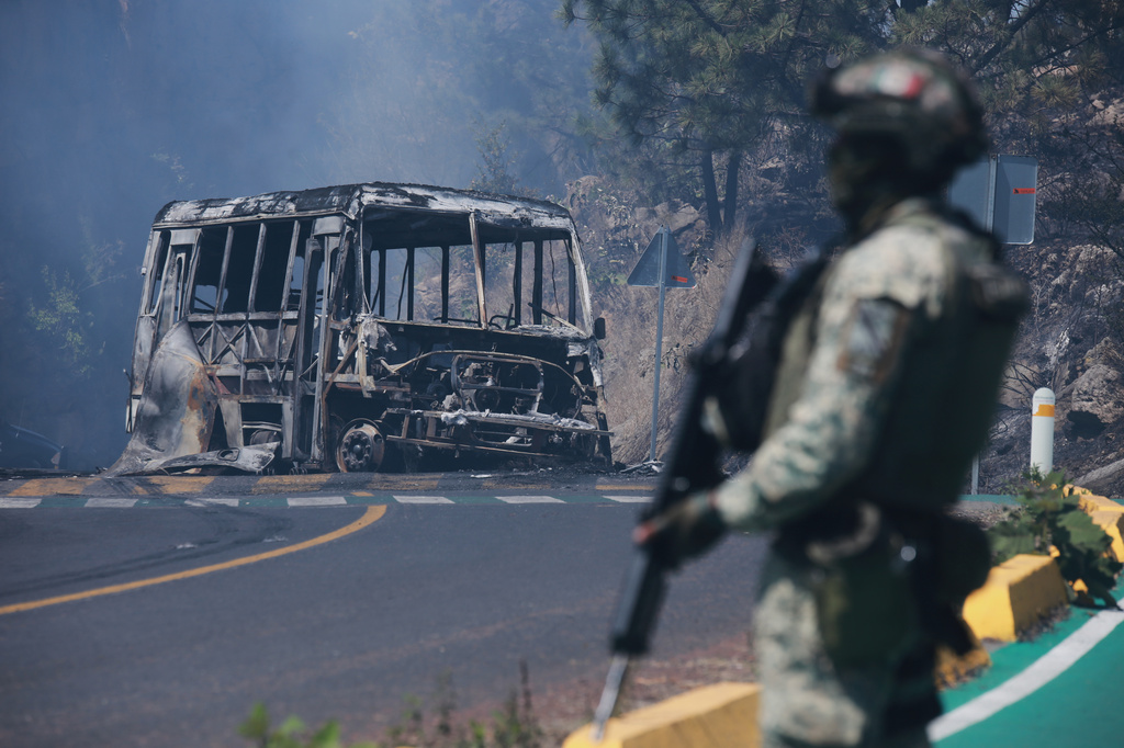 ARCHIVO – Un soldado monta guardia frente a un vehículo en llamas tras ser incendiado en Cointzio, Michoacán, México, el 22 de febrero de 2026, tras la muerte del líder del Cártel Jalisco Nueva Generación, Nemesio Oseguera, también conocido como "El Mencho." (AP Foto/Armando Solis, Archivo)