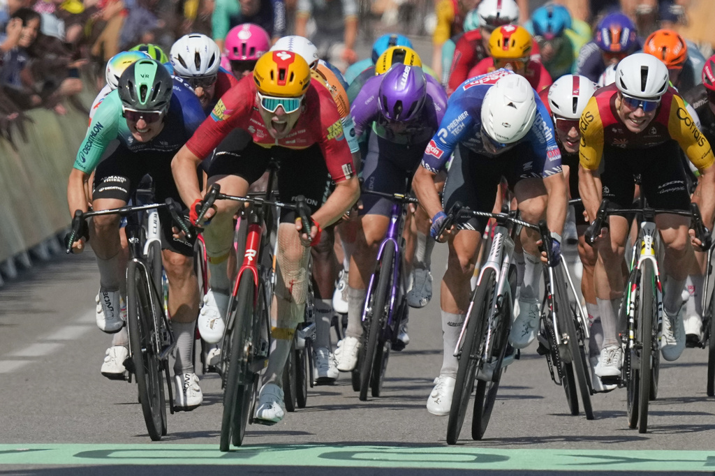 Norway's Soren Waerenskjold, center left, crosses the finish line to win the eleventh stage of the Tour de France cycling race with start in Vichy and finish in Nevers, France, Wednesday, July 15, 2026. (AP Photo/Thibault Camus)