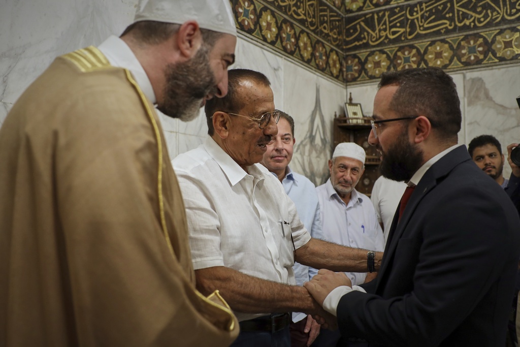 Emirati business magnate Khalaf al-Habtoor, chairman of the Al Habtoor Group, centre, is greeted as he arrives to the Umayyad Mosque as part of a delegation trip to explore investment opportunities in Syria, in the Old City of Damascus on Tuesday, Sept. 9, 2025.(AP Photo/Omar Albam)