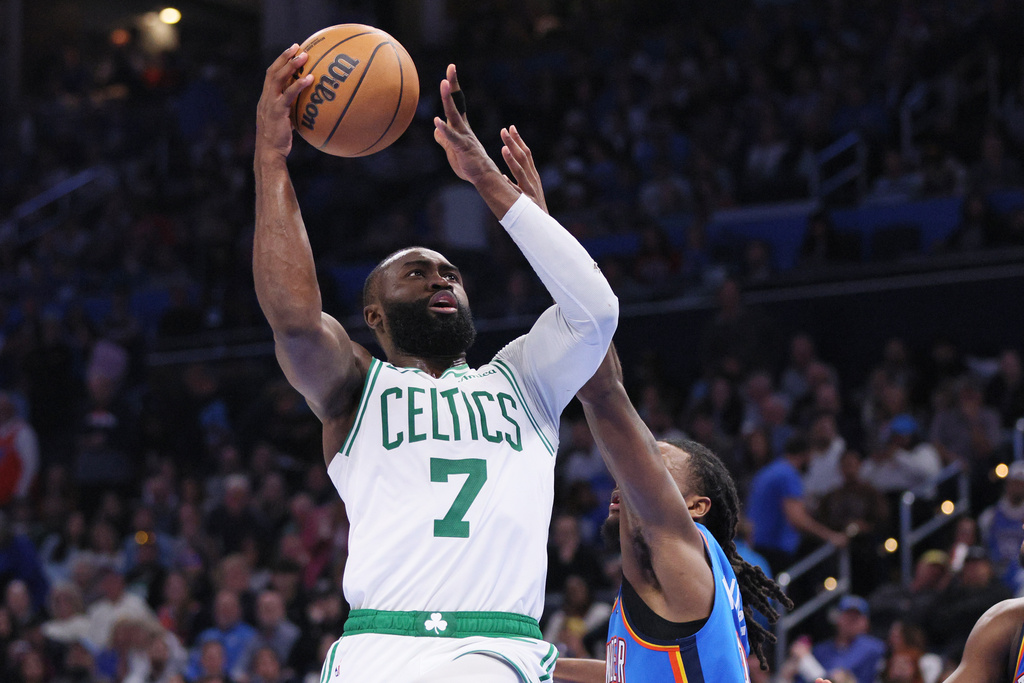 Boston Celtics guard Jaylen Brown takes the ball to the basket against Oklahoma City Thunder guard Cason Wallace, lower right, during the second half of an NBA basketball game, Thursday, March 12, 2026, in Oklahoma City. (AP Photo/Nate Billings)