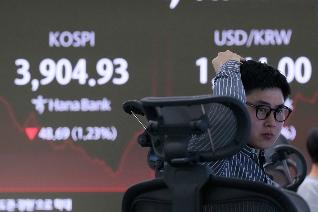 A currency trader watches monitors near a screen showing the Korea Composite Stock Price Index (KOSPI) at the foreign exchange dealing room of the Hana Bank headquarters in Seoul, South Korea, Wednesday, Nov. 19, 2025. (AP Photo/Ahn Young-joon)