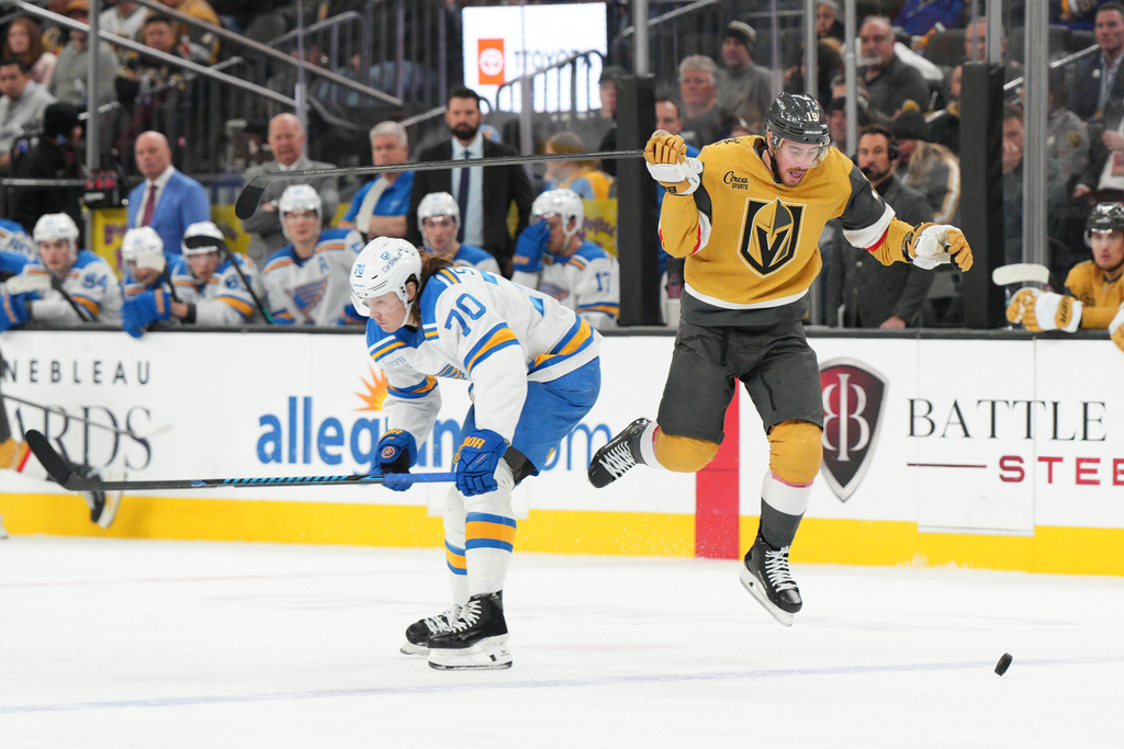 Vegas Golden Knights right wing Reilly Smith jumps past St. Louis Blues center Oskar Sundqvist (70) during the second period of an NHL hockey game Saturday, Jan. 10, 2026, in Las Vegas. (AP Photo/Candice Ward)