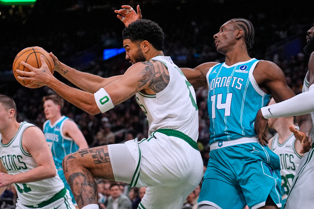 Boston Celtics forward Jayson Tatum, left, grabs a rebound against Charlotte Hornets forward Moussa Diabate (14) during the first half of a NBA basketball game, Tuesday, April 7, 2026, in Boston. (AP Photo/Charles Krupa)