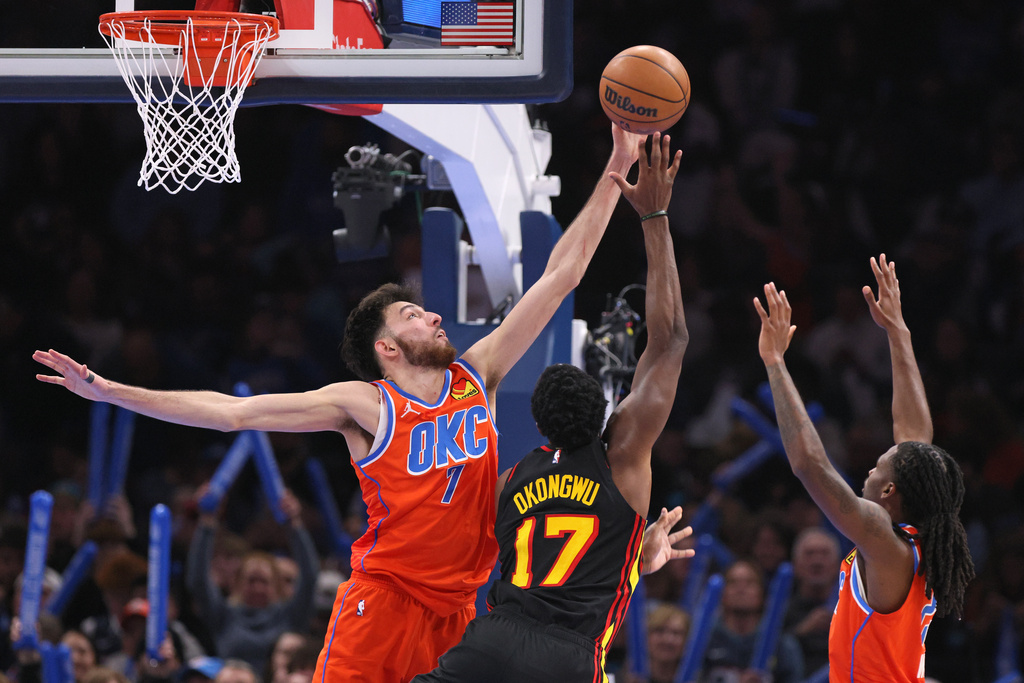 Oklahoma City Thunder center Chet Holmgren (7) attempts to block a shot by Atlanta Hawks forward Onyeka Okongwu (17) as Thunder guard Cason Wallace, right, watches during the second half of an NBA basketball game Monday, Dec. 29, 2025, in Oklahoma City. (AP Photo/Nate Billings)