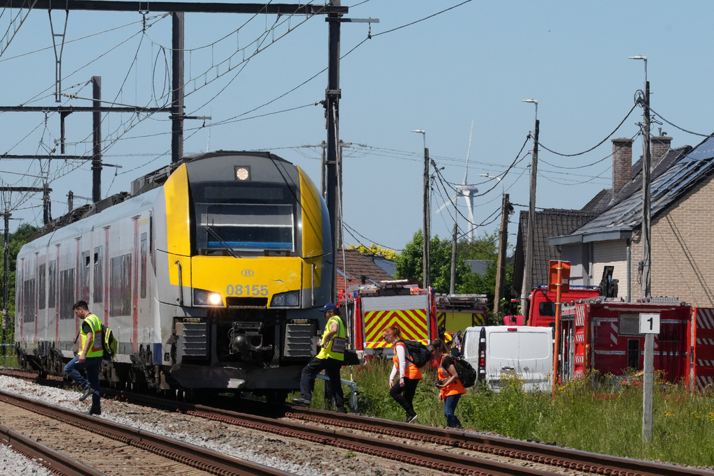Police and rescue personal work around a level crossing where a train collided with a van in Buggenhout, Belgium, Tuesday, May 26, 2026. (AP Photo/Marius Burgelman)