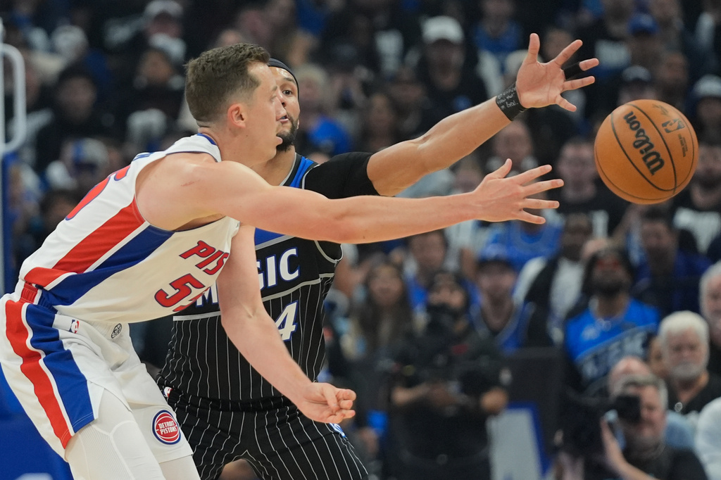 Detroit Pistons forward Duncan Robinson, left, passes the ball against Orlando Magic guard Jalen Suggs (4) during the second half in Game 6 of a first-round NBA basketball playoffs series, Friday, May 1, 2026, in Orlando, Fla. (AP Photo/John Raoux)