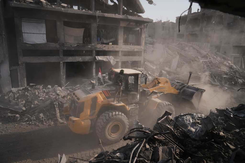 Hamas militants and Egyptian workers search for the bodies of Israeli hostages in the Shijaiyah neighborhood of Gaza City Wednesday, Nov. 5, 2025. (AP Photo/Jehad Alshrafi)