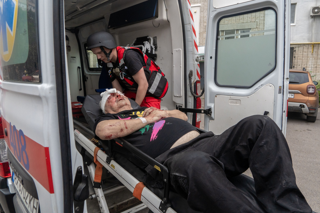 Rescuers evacuate an injured civilian after a residential building was hit following Russia's drone attack in Kharkiv, Ukraine, Sunday, Aug. 9, 2026. (AP Photo/Andrii Marienko)