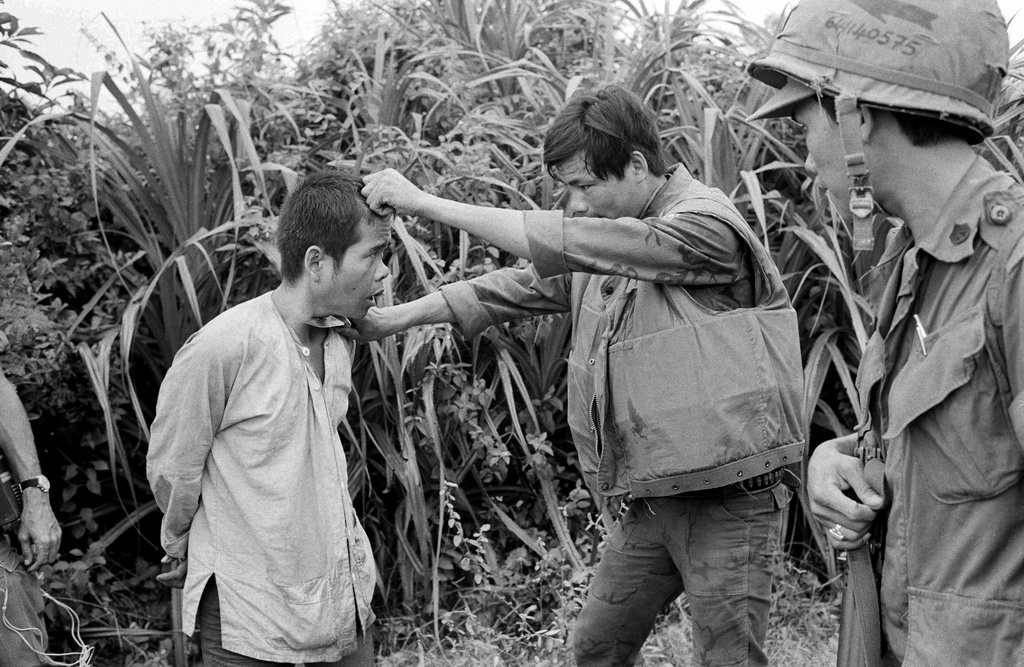 FILE - Holding a knife against the throat of a just-captured Viet Cong guerrilla suspect, a Vietnamese Marine demands information on the whereabouts of his suspected comrades on Nov. 14, 1966, south of DaNang, Vietnam. (AP Photo/Dang Van Phuoc, File)