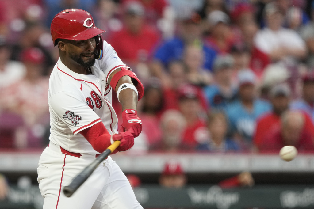 Cincinnati Reds designated hitter Miguel Andujar hits a solo home run during the fourth inning of a baseball game against the Philadelphia Phillies Tuesday, Aug. 12, 2025, in Cincinnati. (AP Photo/Carolyn Kaster)