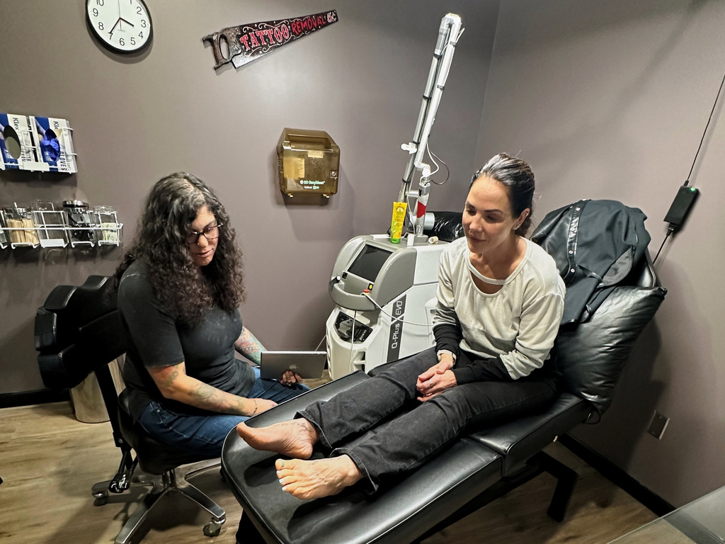 Tracy Herrmann has one of her tattoos removed by Chroma Tattoo Studio Laser Tattoo Removal owner Jaime Howard on Nov. 19, 2025, in West Bloomfield, Mich. (AP Photo/Corey Williams)