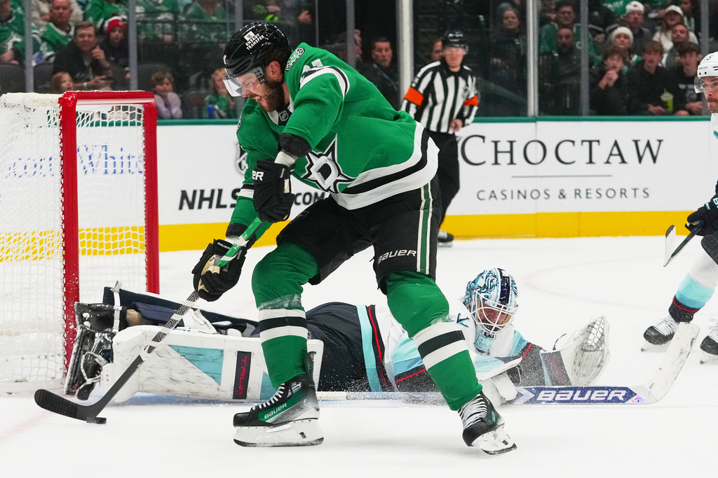 Dallas Stars center Tyler Seguin, top, prepares to score a goal on Seattle Kraken goaltender Matt Murray, bottom, during the first period of an NHL hockey game Sunday, Nov. 9, 2025, in Dallas. (AP Photo/Julio Cortez)