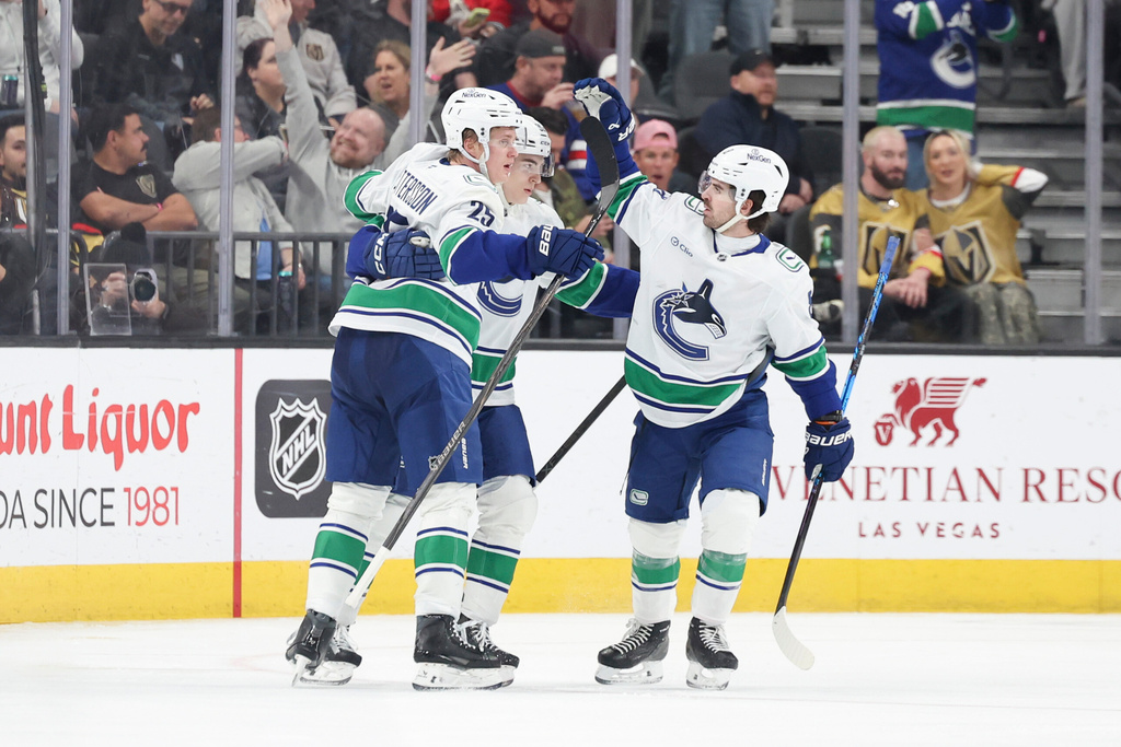 Vancouver Canucks defenseman Elias Pettersson (25), left wing Liam Ohgren (92), and right wing Conor Garland (8) celebrate after Pettersson's goal against the Vegas Golden Knights during the second period of an NHL hockey game Wednesday, Feb. 4, 2026, in Las Vegas. (AP Photo/Ian Maule)
