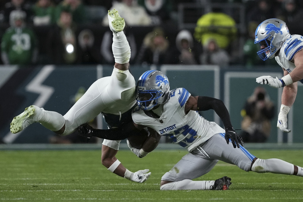Philadelphia Eagles running back Saquon Barkley (26) is tackled by Detroit Lions cornerback Rock Ya-Sin (23) after a catch during the second half of an NFL football game Sunday, Nov. 16, 2025, in Philadelphia. (AP Photo/Matt Slocum)