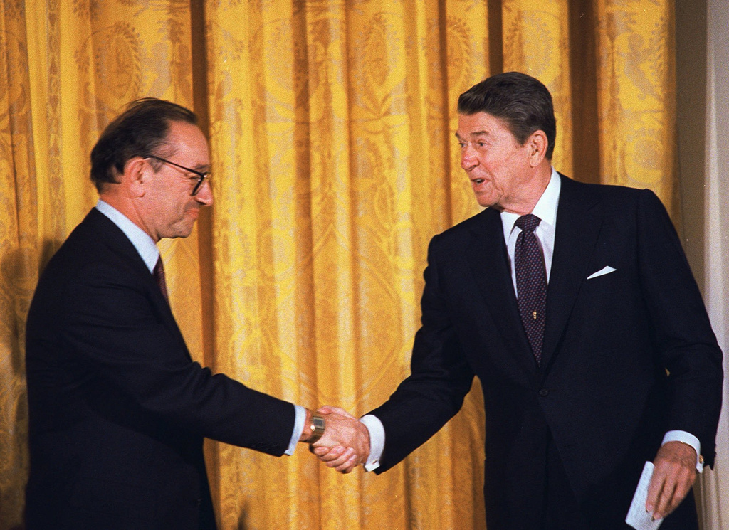 FILE - President Reagan congratulates Alan Greenspan after he was sworn-in as new chairman of the Federal Reserve Board during a ceremony at the White House in this Aug. 11, 1987. (AP Photo/Barry Thumma, file)