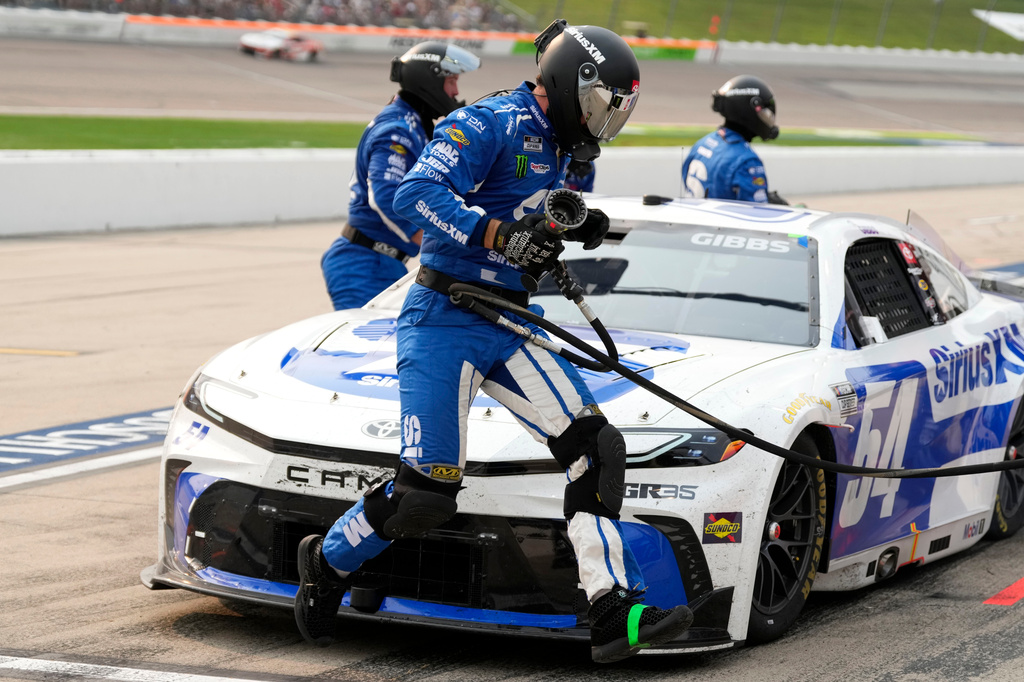 A crew member leaps in front of Ty Gibbs' car during a pit stop in a NASCAR Cup Series auto race, Sunday, Aug. 9, 2026, at Iowa Speedway in Newton, Iowa. (AP Photo/Charlie Neibergall)