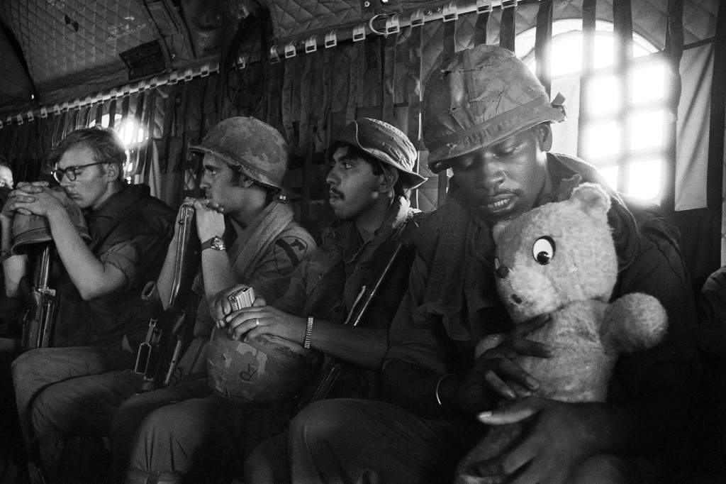 FILE - A GI headed into Kontum in the central highlands with a tank-killing unit, cradles his lucky teddy bear during the helicopter ride in Vietnam, June 3, 1972. (AP Photo/Josip Lee, File)
