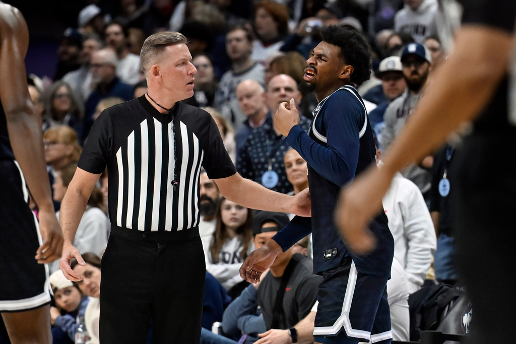 Referee Greg Evans, left, checks on Georgetown guard KJ Lewis in the first half of an NCAA college basketball game against UConn, Saturday, Feb. 14, 2026, in Storrs, Conn. (AP Photo/Jessica Hill)