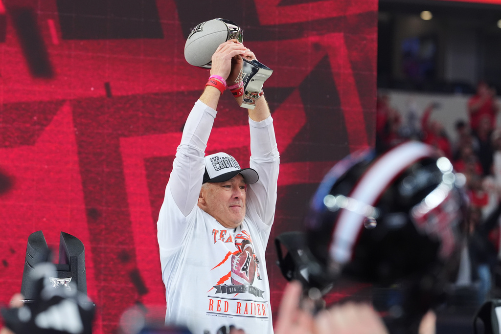 Texas Tech head coach Joey McGuire holds up the trophy after his team's win in the Big 12 Conference championship NCAA college football game against BYU Saturday, Dec. 6, 2025, in Arlington, Texas. (AP Photo/Julio Cortez)
