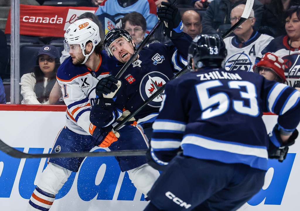 Winnipeg Jets' Tanner Pearson, second from left, and Edmonton Oilers' Riley Stillman, left, collide during first-period NHL hockey game action in Winnipeg, Manitoba, Thursday, Jan. 8, 2026. (John Woods/The Canadian Press via AP)