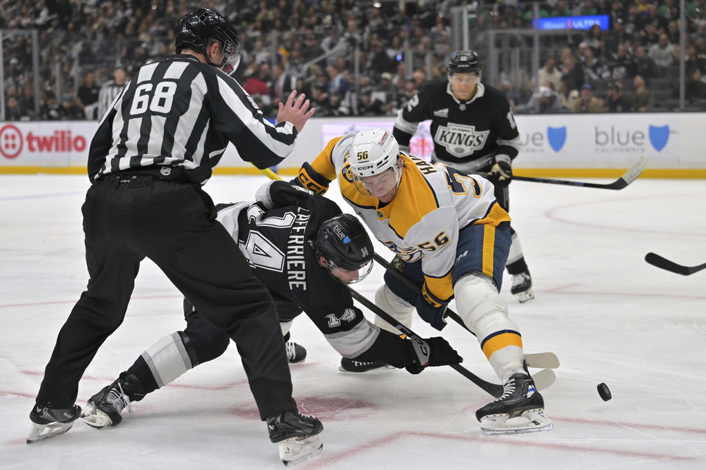 Linesman CJ Murray (68) drops the puck as Los Angeles Kings right wing Alex Laferriere (14) and Nashville Predators left wing Erik Haula face off during the second period of an NHL hockey game Thursday, April 2, 2026, in Los Angeles. (AP Photo/Jayne Kamin-Oncea)