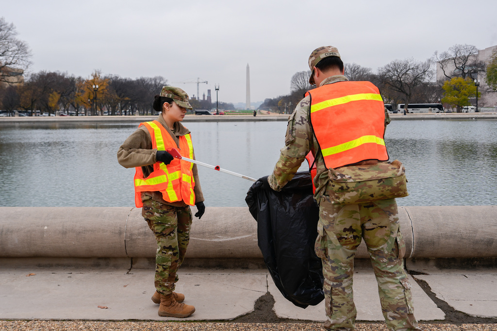 Members of the District of Columbia National Guard pick up trash by the Capitol reflecting pool, Friday, Nov. 21, 2025, in Washington. (AP Photo/Julia Demaree Nikhinson)