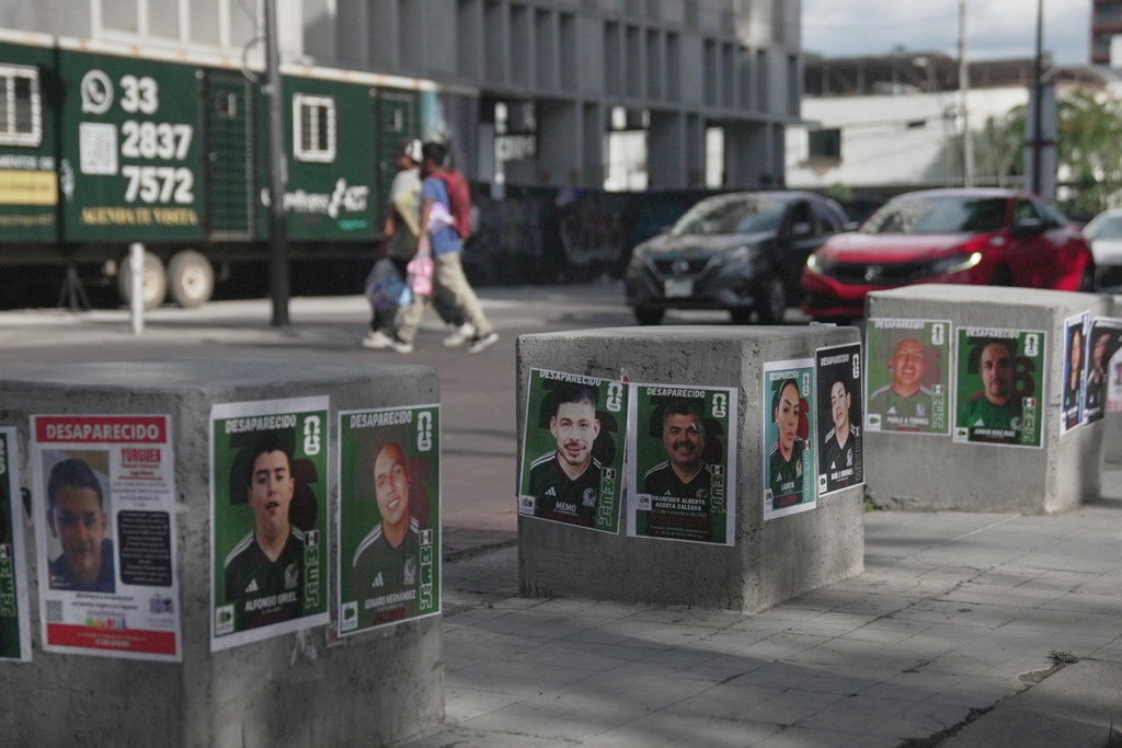 Posters of missing people wearing Mexican national soccer team jerseys to resemble World Cup sticker album cards are posted on a street in Guadalajara, Mexico, Tuesday, June 16, 2026. (AP Photo/Martin Silva)