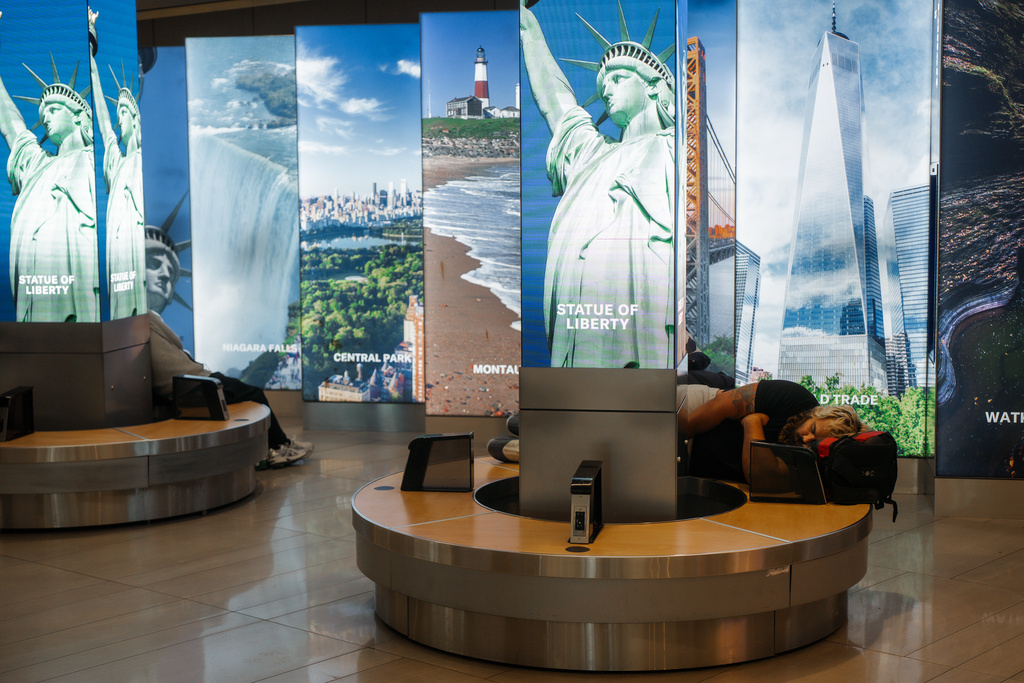 A traveler sleeps at Laguardia International Airport on Saturday, Nov. 8, 2025, in New York. (AP Photo/Olga Fedorova)