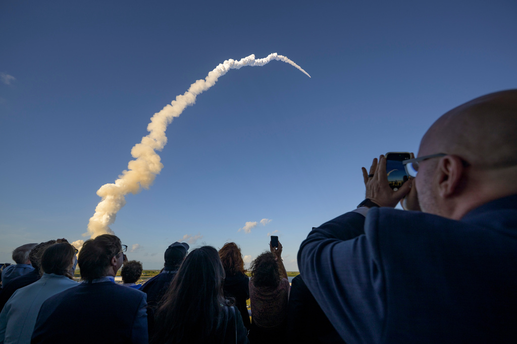 In this photo provided by NASA, guests watch the launch of the Space Launch System (SLS) rocket and Orion spacecraft for the Artemis II mission to the moon at NASA's Kennedy Space Center in Florida on Wednesday, April 1, 2026. (Bill Ingalls/NASA via AP)