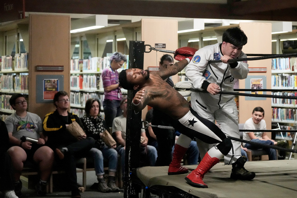 Astro Knox, right, hits a member of Young Steel during a tag team match at a Lucha Libro pro wrestling event at Benicia Public Library Saturday, May 2, 2026, in Benicia, Calif. (AP Photo/Jeff Chiu)