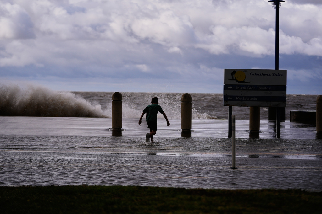 Josiah Carpenter, 8, frolics in the floodwaters on Lakeshore Drive along Lake Pontchartrain as Tropical Storm Bertha approaches the Louisiana Coast Wednesday, July 22, 2026, in New Orleans. (AP Photo/Gerald Herbert)