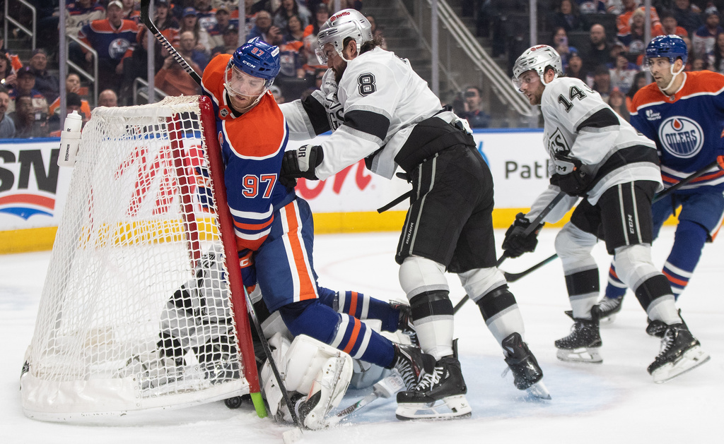 Los Angeles Kings' Drew Doughty (8) checks Edmonton Oilers' Connor McDavid (97) into the net during an overtime of an NHL hockey game in Edmonton on Saturday, Jan. 10, 2026. (Jason Franson/The Canadian Press via AP)
