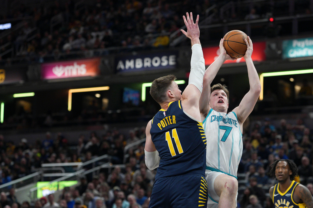 Charlotte Hornets guard Kon Knueppel (7) looks to shoot around Indiana Pacers center Micah Potter (11) during the first half of an NBA basketball game in Indianapolis, Thursday, Feb. 26, 2026. (AP Photo/AJ Mast)