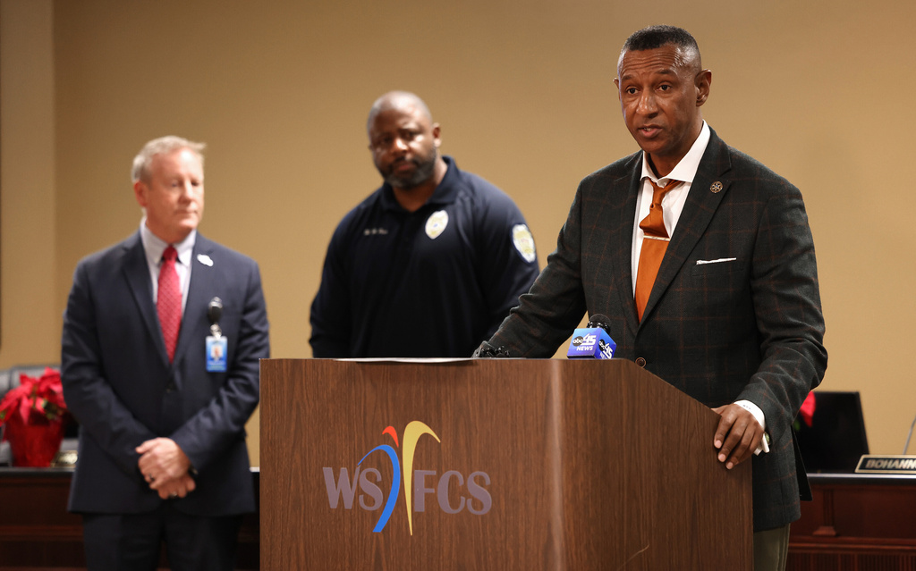 Forsyth County Sheriff Bobby Kimbrough, right, with Winston-Salem/Forsyth County Schools Superintendent Don Phipps, left, and Winston-Salem Police Chief William Penn, speaks after a fatal stabbing at North Forsyth High School in Winston-Salem, N.C., Tuesday, Dec. 9, 2025. (Walt Unks/The Winston-Salem Journal via AP)