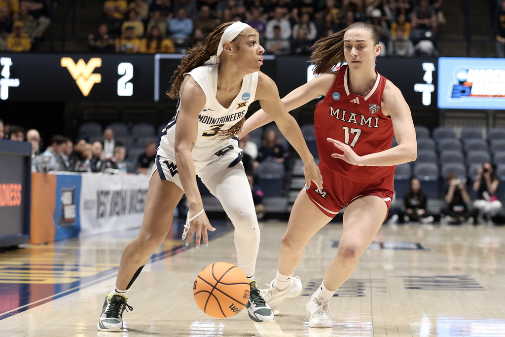 West Virginia guard Gia Cooke (3) is defended by Miami (Ohio) guard Nuria Jurjo (17) in the first half in the first round of the NCAA college basketball tournament, Saturday, March 21, 2026, in Morgantown, W.Va. (AP Photo/Kathleen Batten)