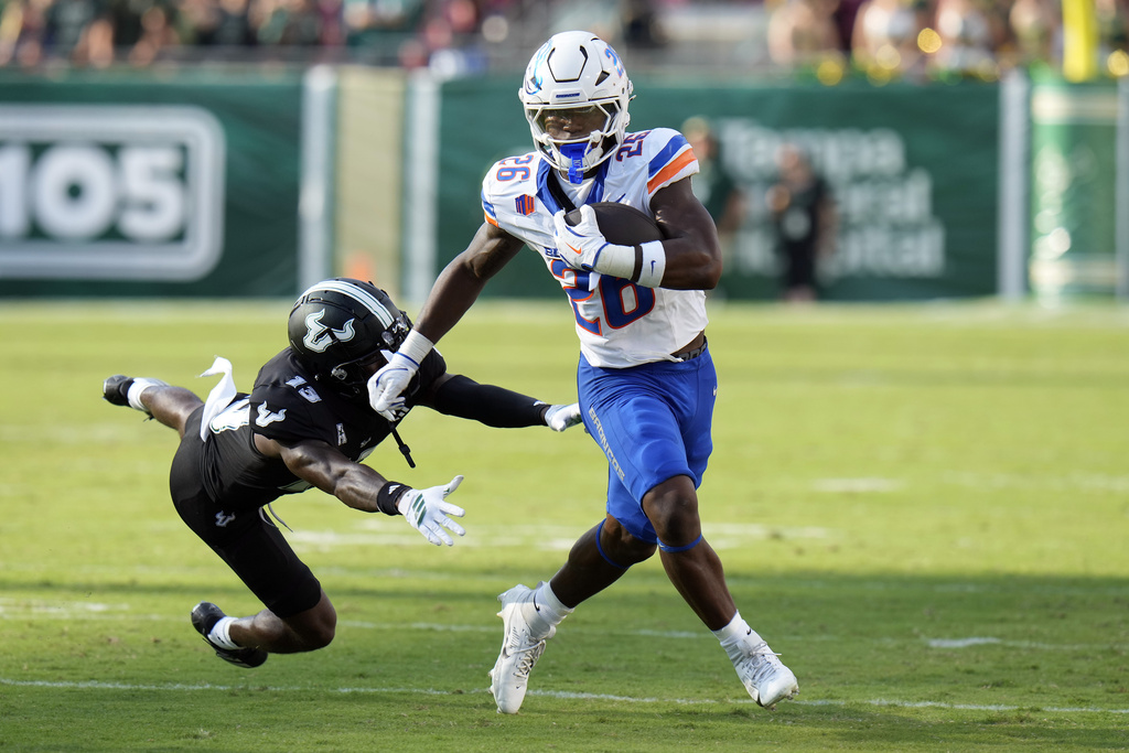 Boise State running back Sire Gaines (26) breaks free from South Florida defensive back Kajuan Banks (13) during the first half of an NCAA college football game Thursday, Aug. 28, 2025, in Tampa, Fla. (AP Photo/Chris O'Meara)